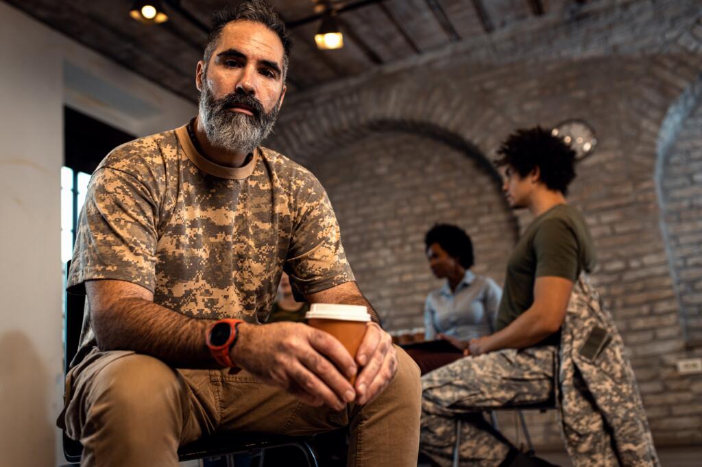 Portrait of male veteran in PTSD support group looking at camera.